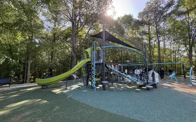 Newly renovated playground at Davis Drive Park in Cary featuring a large climbing structure and rubber safety surface.